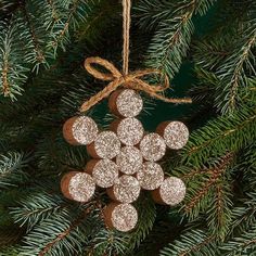 a christmas ornament hanging from a pine tree with glittered circles on it