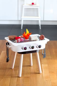 a small white grill sitting on top of a hard wood floor