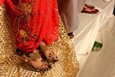 a woman in red and gold dress standing next to other people