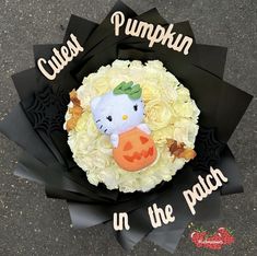 there is a fake hello kitty pumpkin in the center of this flower bouquet that says, cause pumpkin in the patch