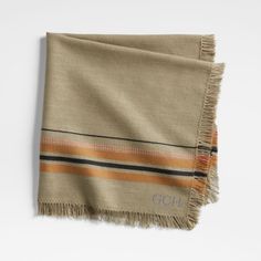 a tan and black striped blanket on a white surface with fringes around the edges