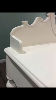 a white bed with an ornate headboard and foot board on top of the bed