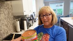 an older woman holding a can of canned food