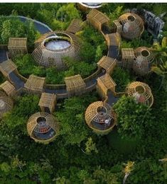 an aerial view of some huts in the middle of a forest with lots of trees