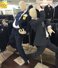 two mannequins dressed in suits and ties are dancing