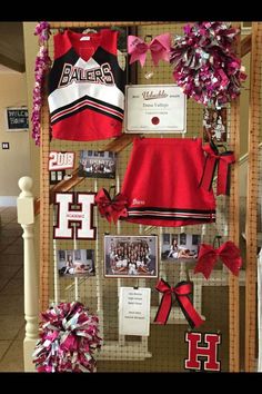 a display case with cheerleaders and ribbons on it's sides, hanging from the wall