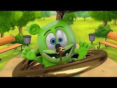 a green cartoon character sitting on top of a bench