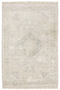 an antique rug with fringes on the edges and a medallion design in grey, beige and white