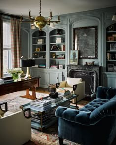 a living room filled with lots of furniture and bookshelves next to a window