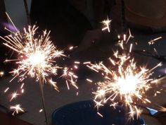 two sparklers that are sitting on top of a blue plate and one is lit up