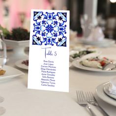 a table set up with place cards and silverware for an elegant wedding reception in blue and white