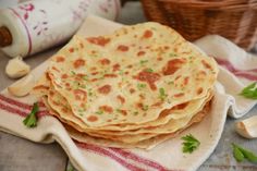 three flat breads on a plate with garlic and parsley in the background, ready to be eaten