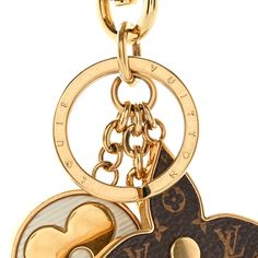 a gold and black keychain with two heart shaped charms hanging from it's sides