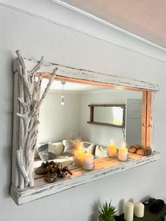 a mirror that is on the side of a wall with candles in front of it