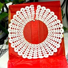 a white doily sitting on top of a red box