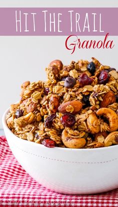 a white bowl filled with granola on top of a red and white checkered table cloth