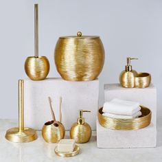 gold bathroom accessories displayed on white counter top