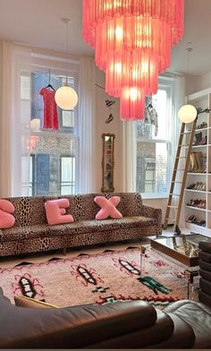 a living room filled with furniture and a pink chandelier