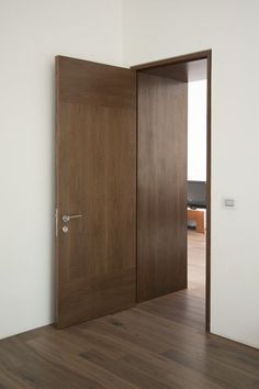 an open wooden door in a white room