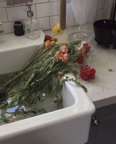 some flowers are sitting in a sink with water