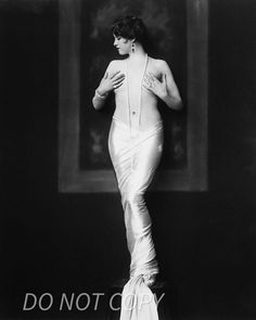 an old black and white photo of a woman in a dress with her back to the camera