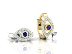 two gold rings with blue and white stones on them, one is in the shape of an eye