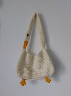 a crocheted bag hanging on the wall with two yellow ducks attached to it