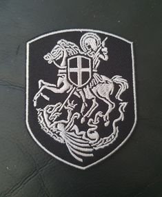 a black and white patch with a coat of arms emblem on it's side