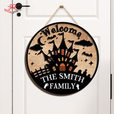 a welcome sign hanging on the front door of a house with bats and pumpkins