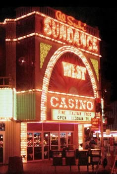 a casino building with lights on it's sides and the entrance lit up at night