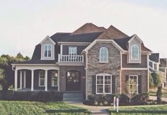 a large brick house with white trim on the windows and balconies is shown