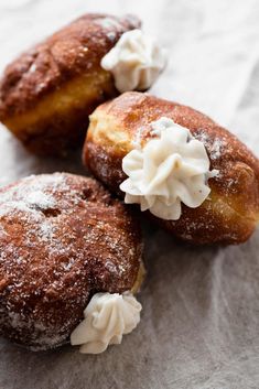 three donuts with icing and powdered sugar on them