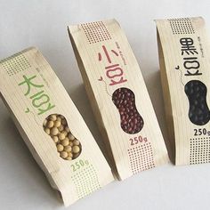 three wooden boxes with different types of beans in them on a white tablecloth background