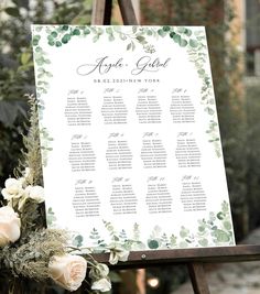 an easel with flowers and greenery on it is shown for guests to sign