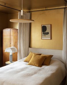 a white bed sitting next to a window in a bedroom