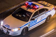 a police car with its lights on driving down the street