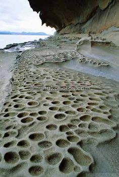 the sand has holes in it as if they were made by people on the beach