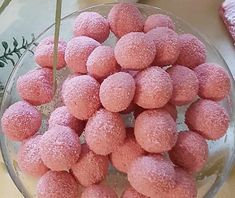 a glass bowl filled with powdered donuts on top of a table