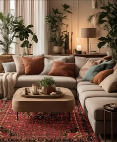 a living room filled with lots of furniture and plants on top of a red rug