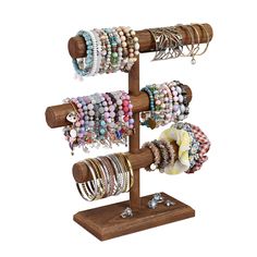 a wooden jewelry rack with bracelets and rings on it's display stand in front of a white background