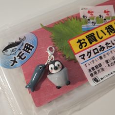 an animal keychain sitting on top of a plastic bag next to a sign