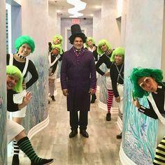 a group of people with green wigs are standing in a hallway and posing for the camera