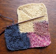 a crocheted dish cloth with a knitting needle in the middle on a wooden table