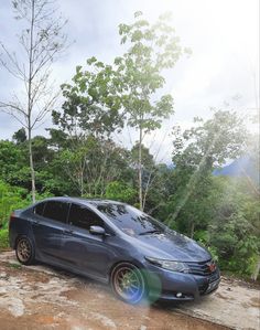 a grey car parked on top of a dirt road