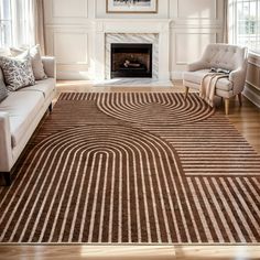 a living room filled with furniture and a large rug on the floor in front of a fire place