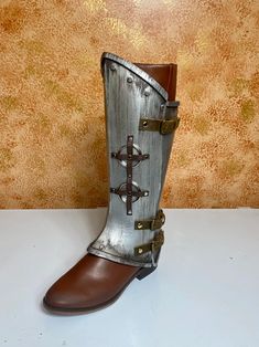 a pair of boots with metal straps and buckles on the side, sitting on a table