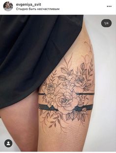 a woman's thigh with flowers on it and a black band around the leg