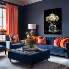 a living room with blue couches, orange pillows and paintings on the wall above them