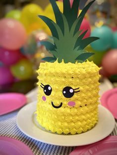 a yellow pineapple cake with a smiley face on it's side sitting on a plate