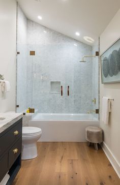 a bathroom with wood floors and white walls